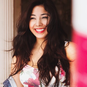 A beautiful woman with wavy hair is smiling.