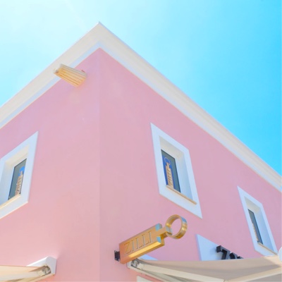 A picture of the top of a building painted beautifully by pink paint.